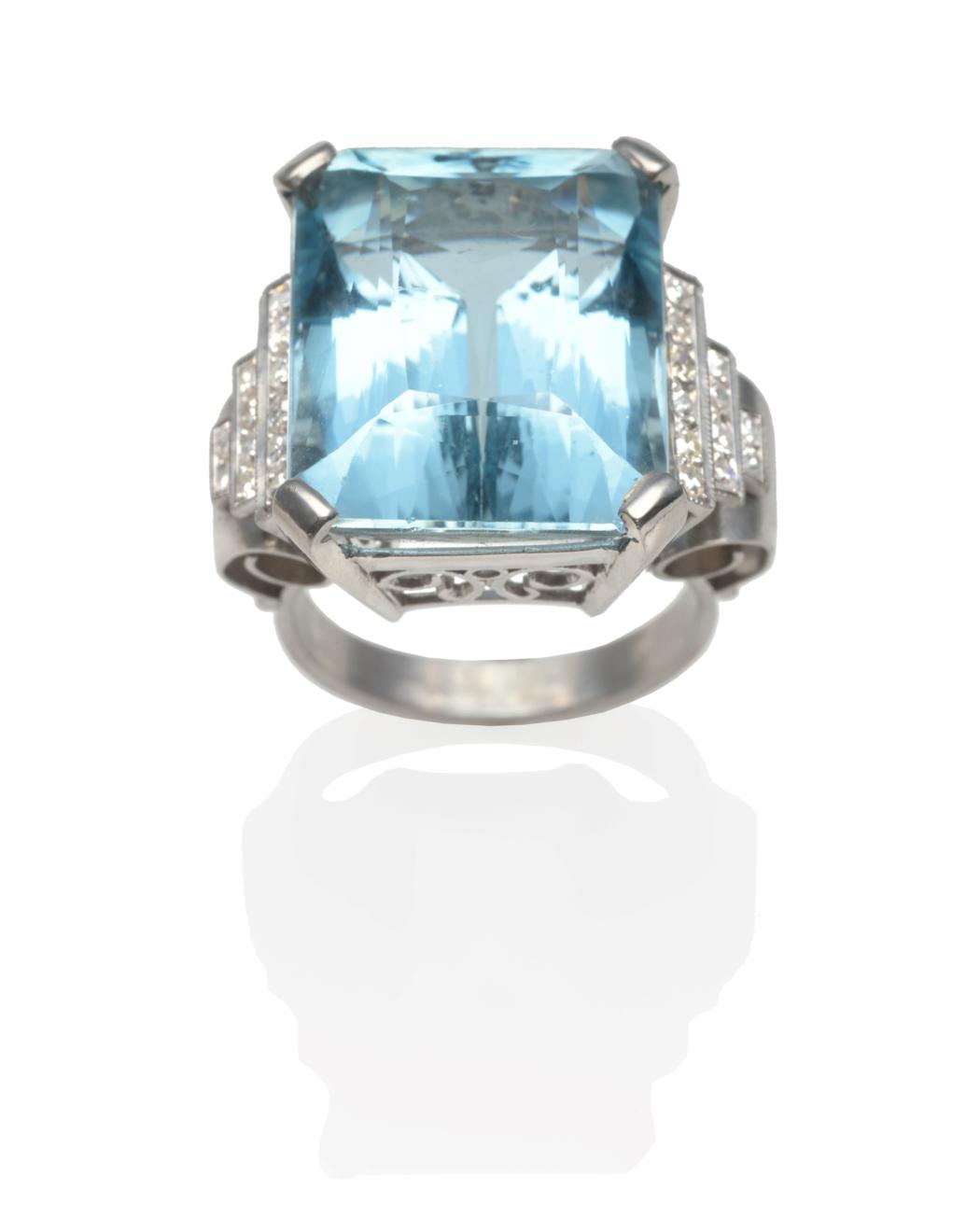 An Art Deco Aquamarine and Diamond Ring, an emerald-cut aquamarine in a white claw setting and set