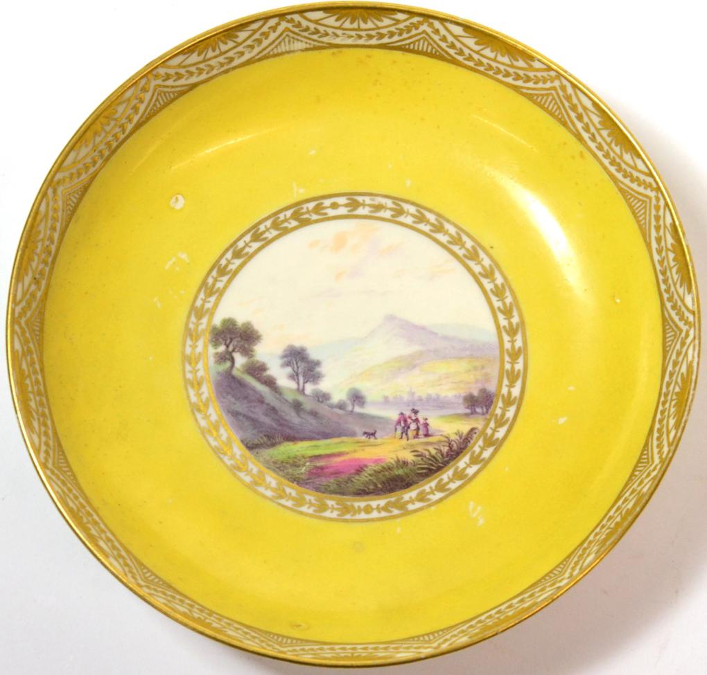 A Pinxton Porcelain Saucer, circa 1800, painted with a ''View Near Baslow, Derbysh.'' on a yellow