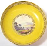 A Pinxton Porcelain Saucer, circa 1800, painted with a ''View Near Baslow, Derbysh.'' on a yellow