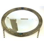 An Arts and Crafts Pewter Wall Mirror, circa 1910, of oval form with bevelled plate, the hammered