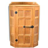 A Robert ''Mouseman'' Thompson Panelled Oak Hanging Corner Cupboard, the single door opening to