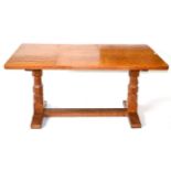A Robert ''Mouseman'' Thompson Oak 5ft Refectory Table, on two octagonal legs, joined by a floor