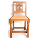A Robert ''Mouseman'' Thompson Oak Lattice Back Dining Chair, with cow hide upholstered seat, on two