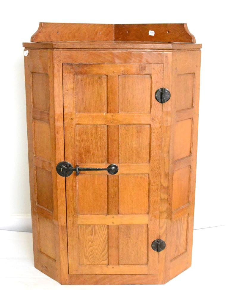 A Robert ''Mouseman'' Thompson Panelled Oak Hanging Corner Cupboard, the single door opening to