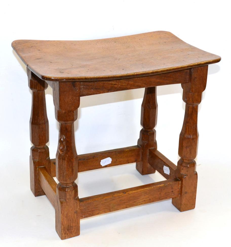 A Robert ''Mouseman'' Thompson Oak Dish Top Stool, on four octagonal legs joined by stretchers, with