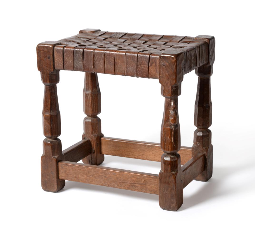 A Robert ''Mouseman'' Thompson Oak Stool, with lattice leather top, on four octagonal legs joined by