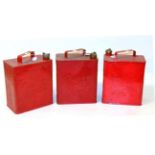 Three Vintage Red Painted Fuel Cans, stamped Pratts; three 1930s circular tax disc holders; a