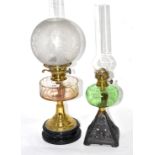 Two Victorian oil lamps, one with clear glass reservoir, the other with green glass reservoir