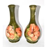 A pair of Moorcroft pottery Hibiscus pattern bottle vases