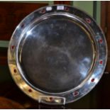 An Arts & Crafts silver plated charger, the rim with twelve inset cabochons, stamped JJ Buchan