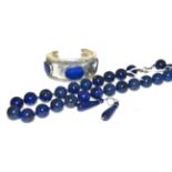 A lapis lazuli bead necklace, a pair of lapis lazuli drop earrings and a lapis lazuli cuff bangle