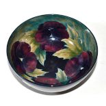 A William Moorcroft Pansy bowl, impressed factory mark and green painted signature (restored rim)