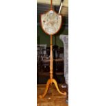 A 19th century satinwood polescreen, with embroidered shield form panel, fluted column and tripod