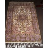 A part silk Kashmir rug, the ivory field of scrolling vines around the stellar medallion framed by