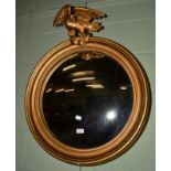 A Regency style convex wall mirror in moulded gilt frame, eagle finial