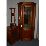 A reproduction cherrywood free-standing corner cupboard, with bevelled glass panels enclosing