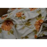 A pair of peach floral embroidered curtains on white linen ground