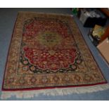 An Indian rug of Isaphan design, the raspberry field of vines around a central medallion, framed