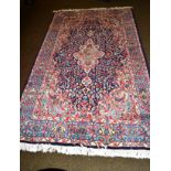 Kirman rug, South East Iran, the deep indigo floral field centred by an ivory pole medallion