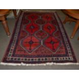 A West Persian village rug, the crimson geometric lattice field enclosed by ivory borders, 234cm