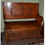 An early 20th century carved oak monks bench