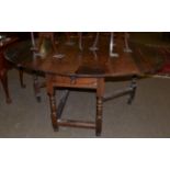 An early 18th century joined oak six-seater gateleg table, raised on spindle turned legs joined by a