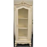 A Cream Painted Grille Door Cabinet in the Louis XV style, with a carved pediment above an arched