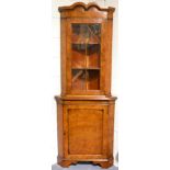 A Reproduction Burr Walnut Corner Cabinet, with a moulded cornice above an astragal glazed door, the