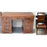 A Hardwood Desk of recent date, with three drawers above two cupboard doors, raised on a platform