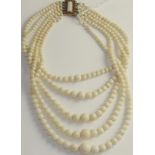 A coral bead necklace, five strands of graduated bleached coral beads knotted to a coral set rose