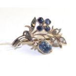 A French sapphire and diamond spray brooch, a flower set with four oval cut sapphires to a spray set