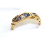 An 18 carat gold sapphire and diamond ring, three graduated round cut sapphires, spaced by two old