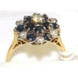 An 18 carat gold sapphire and diamond cluster ring, set throughout with round brilliant cut diamonds