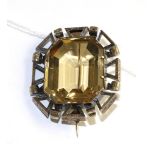 A Citrine brooch, an emerald-cut citrine in a yellow claw setting and within a fancy pierced frame
