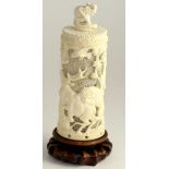 A Japanese ivory tusk vase and cover, Meiji period, pierced with tigers attacking an elephant and