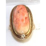 A coral cameo and diamond ring, an oval coral cameo carved with a classical female bust in a