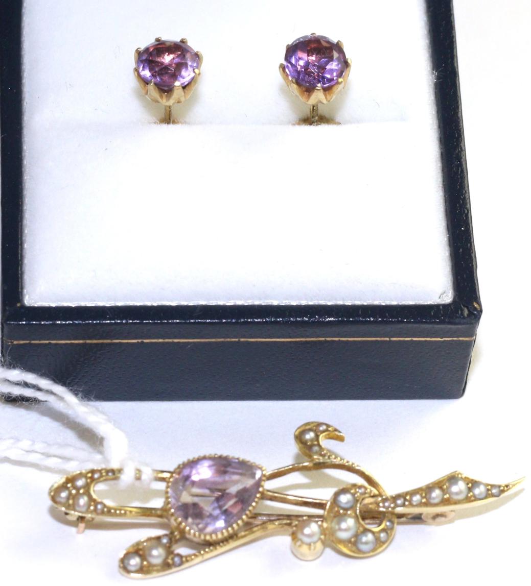 An Art Nouveau amethyst and seed pearl brooch, an oval cut amethyst in a yellow milgrain setting