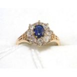 An 18 carat gold sapphire and diamond cluster ring, an oval cut sapphire within a border of old