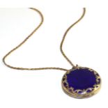 A blue guilloche enamel locket, a circlar locket with applied scroll decoration, hinged to open