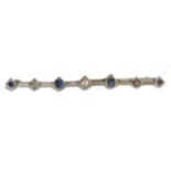 A diamond and sapphire bar brooch, a central old cut diamond spaced by round cut sapphires and