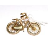 A novelty bicycle brooch, with moving wheels and applied horseshoe, set with seed pearls, measures
