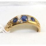 An 18 carat gold sapphire and diamond cluster ring, three oval cut sapphires spaced by old cut