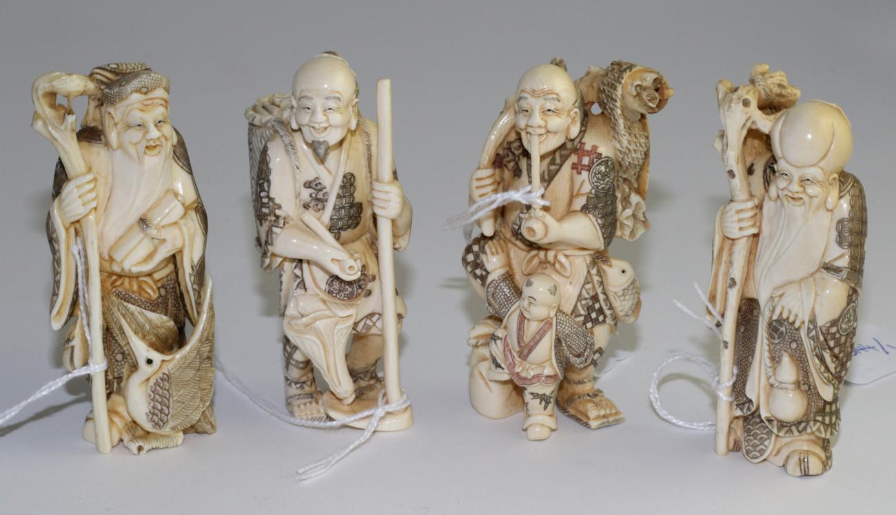 A set of four Japanese carved ivory figures of Immortals, early 20th century, each holding a