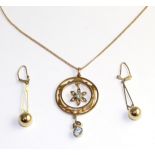 An aquamarine and seed pearl pendant, a round cut aquamarine in a yellow milgrain setting within a