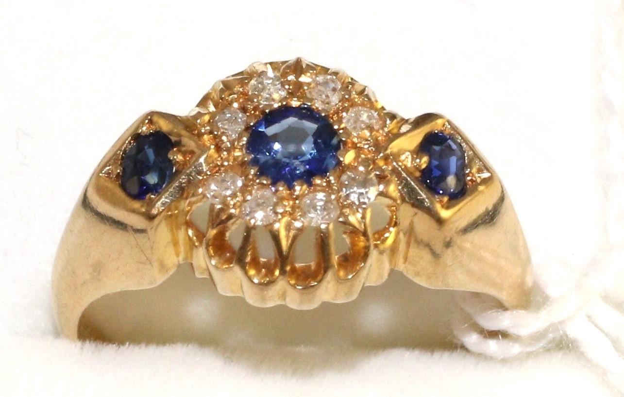 An 18 carat gold sapphire and diamond ring, a round cut sapphire within a border of eight-cut