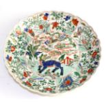 A Chinese porcelain dish, Kangxi, painted in famille vert enamels with mythical beasts and foliage