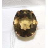 A smokey quartz ring, an oval cut smokey quartz in a yellow claw setting with pierced underbezel, on