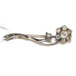 A diamond spray brooch, a flower head set with seven old cut diamonds in white collet and claw