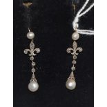 A pair of pearl and diamond drop earrings, a pearl stud suspends a rose cut diamond set fleur-de-lis