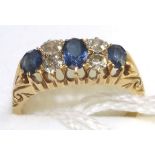 An 18 carat gold sapphire and diamond ring, three graduated oval cut sapphires spaced by two pairs